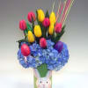 Bouquet of yellow and pink tulips in a bunny-decorated vase