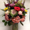 Mixed bouquet with roses, gerbera daisies, hydrangeas, and a glass vase