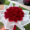 Bouquet of red roses wrapped in white paper