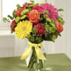Mixed bouquet of roses, gerbera daisies, and carnations in a glass vase