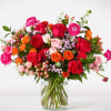 Mixed bouquet of roses and ranunculus in a clear glass vase