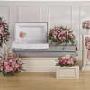 Pink floral funeral casket spray with matching standing wreaths and arrangements