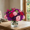 A stunning arrangement of vibrant roses and carnations in rich hues, creating