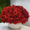 Vivid red roses arranged in a full dome with white accents in
