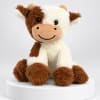 Plush cow toy sitting on a white pedestal