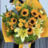 Bouquet of yellow sunflowers, roses, and lilies wrapped in bright orange paper
