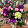 Mixed pink and purple floral arrangement in a clear glass vase