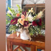 Mixed bouquet in a white vase with roses, orchids, and calla lilies