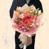 Pink bouquet of roses and lilies wrapped in pastel paper