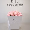 A charming arrangement of soft pink roses, beautifully presented in a signature