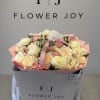 Bouquet of cream and blush roses with pale dahlias in a gift box