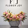 A graceful arrangement of pink and soft yellow roses, delicate hydrangeas, and