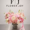 A romantic blend of pink roses, lush peonies, ranunculus, and delicate seasonal