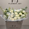 Cream and white bouquet of roses and dahlias in a branded box