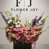 Large pink and purple floral arrangement in a dark container