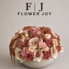 A sophisticated arrangement of taupe, blush, ivory, and dusty rose blooms, artfully