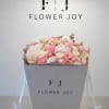 A luxurious arrangement of soft pink and ivory roses, lush peonies, delicate