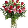 Red roses and pink lilies in a clear glass vase