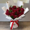 Bouquet of red roses wrapped in white paper with a red ribbon