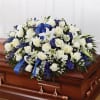 White and blue floral spray on a wooden casket