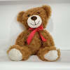 Brown teddy bear with a red ribbon bow