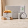 Bath and body gift set with soap, balm, and lip balm in a gray box