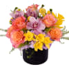 Mixed bouquet of pink roses, orchids, and yellow flowers in a black vase