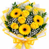 Yellow roses and gerbera daisies with white filler flowers in wrapped bouquet