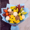 Bouquet of yellow and white flowers wrapped in blue paper