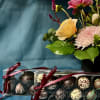 Gift set with mixed flower arrangement in a black vase and two boxes of assorted chocolate truffles
