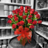 Bouquet of red roses in a glass vase with a red ribbon