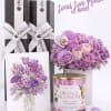 Gift set with purple flowers, chocolate boxes, and a pink candle