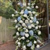 Large standing floral spray with white roses and blue hydrangeas