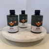 Three plant care bottles on a round white pedestal