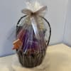 Gift basket wrapped in clear cellophane with a bow