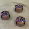 Three small candles in round containers with colorful labels