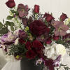 Deep burgundy and white floral arrangement in a black vase