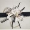 White flower corsage with black ribbon on a wristband