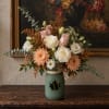 Mixed bouquet of roses and mums in a green mason jar vase