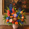 Colorful mixed flower arrangement in a pink ribbed vase