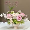 A soft blend of Blush Pink Roses, Hellebores, Sweet Peas, and airy