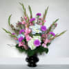Pink and purple floral arrangement in a black vase