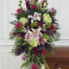 A lush, tall standing spray that reads as a polished floral tribute-this