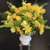 Yellow floral arrangement in a white vase with roses and spider mums