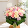 A full cluster of pink and cream roses softened by lavender filler