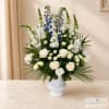 White and blue floral arrangement in a white vase