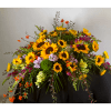 Large arrangement of sunflowers and mixed blooms in a dark container