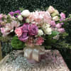 Pink and purple mixed flower arrangement in a ribbon-tied vase