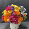 Bright mixed bouquet in a white vase with a striped ribbon