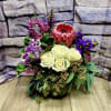 Bouquet with cream roses, a red protea, and purple flowers